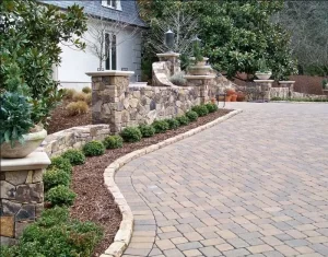 Brick driveway with landscaped border garden beds.